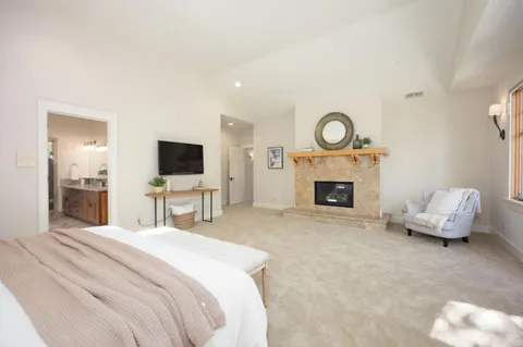 a bathroom with a sink double vanity granite tub shower and a mirror