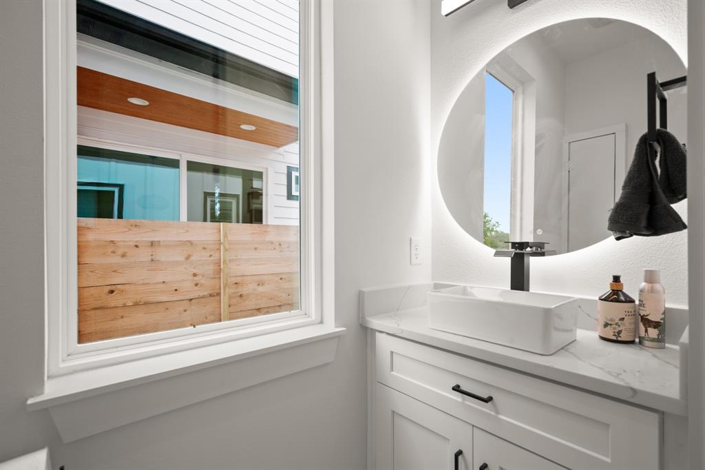 5305 Ledesma Road, Unit 4 Austin, TX 78721 - Photo 11 of 27 a bathroom with a sink a vanity and a mirror