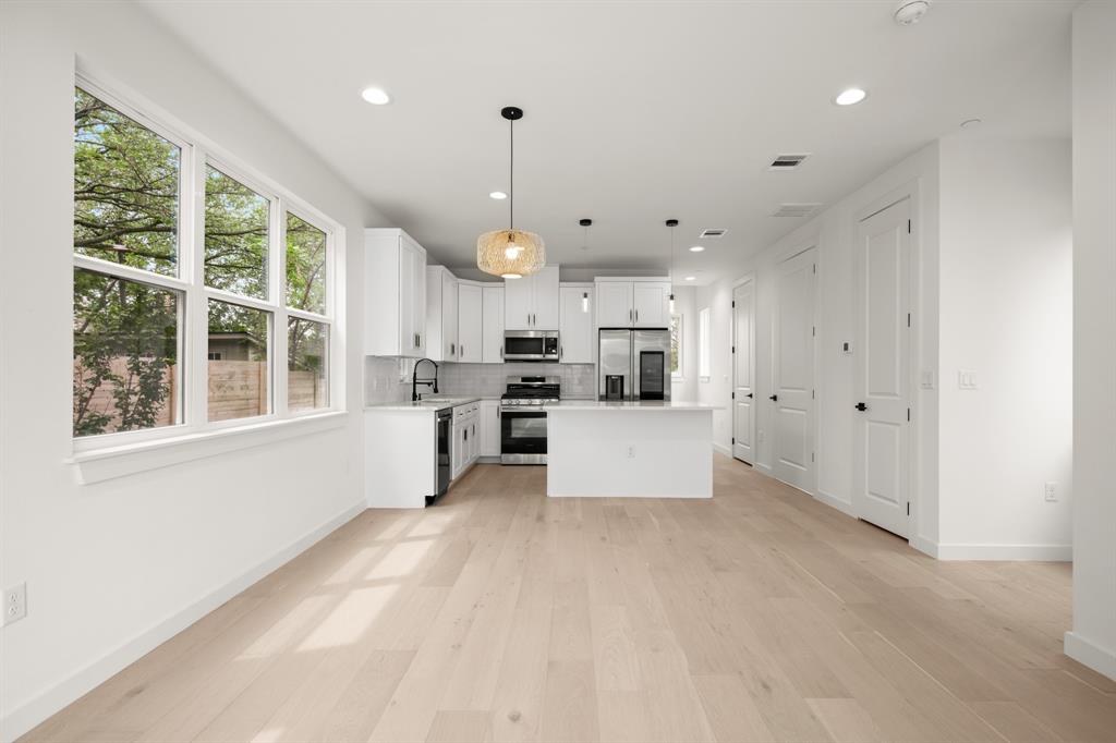 5305 Ledesma Road, Unit 4 Austin, TX 78721 - Photo 5 of 27 a large white kitchen with wooden floors and white walls