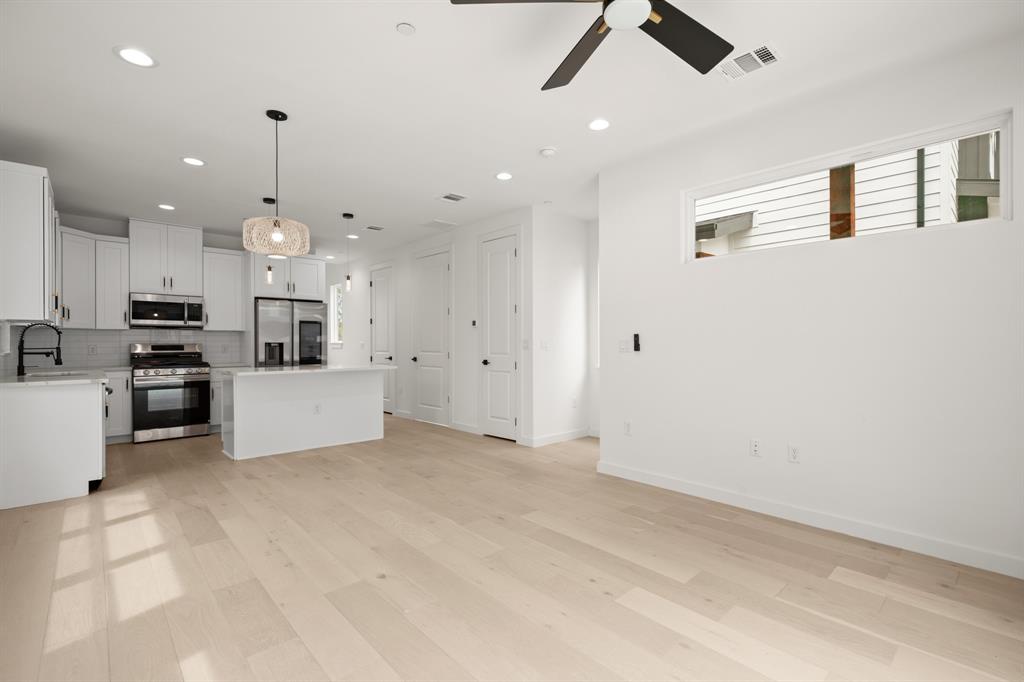 5305 Ledesma Road, Unit 4 Austin, TX 78721 - Photo 27 of 27 a large white kitchen with kitchen island a stove a sink a refrigerator and white cabinets