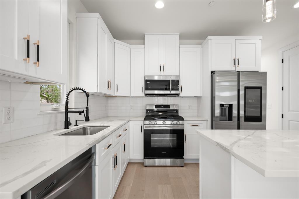 5305 Ledesma Road, Unit 4 Austin, TX 78721 - Photo 8 of 27 a kitchen with stainless steel appliances granite countertop a sink stove and refrigerator