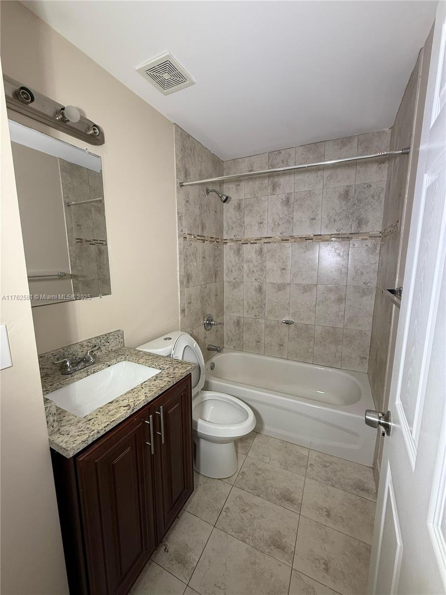 1990 Northwest 4th Court, Unit 7 Miami, FL 33136 - Photo 5 of 6 a bathroom with a granite countertop sink toilet and shower