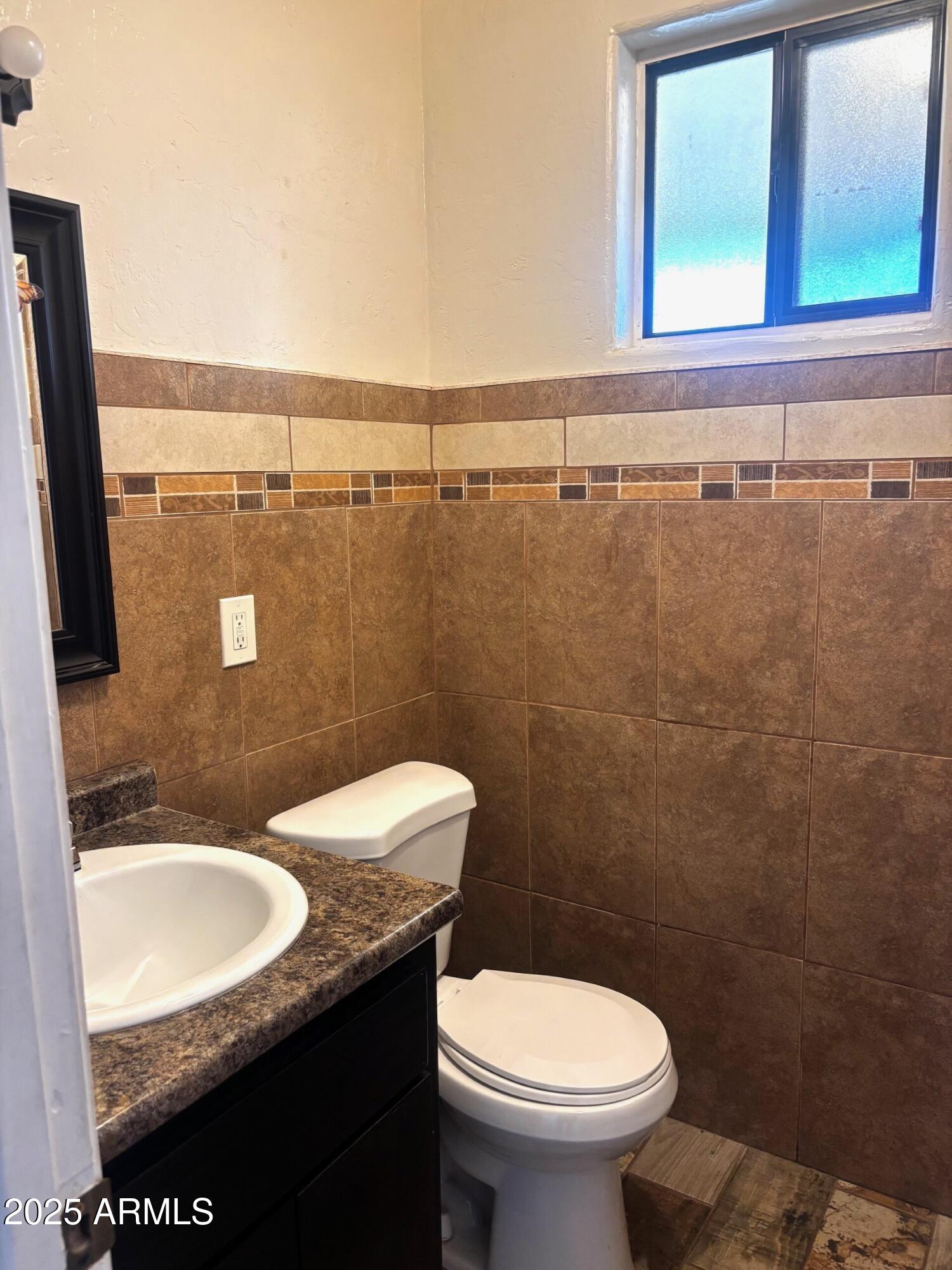 814 East 13th Street Douglas, AZ 85607 - Photo 13 of 14 a bathroom with a granite countertop toilet sink and mirror