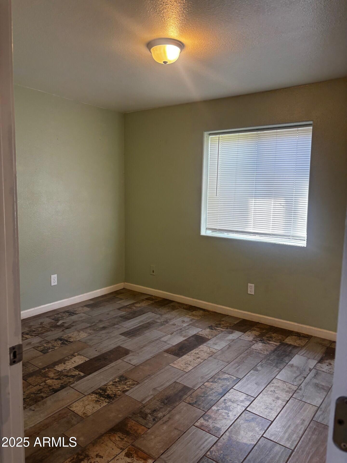 814 East 13th Street Douglas, AZ 85607 - Photo 8 of 14 an empty room with wooden floor and windows