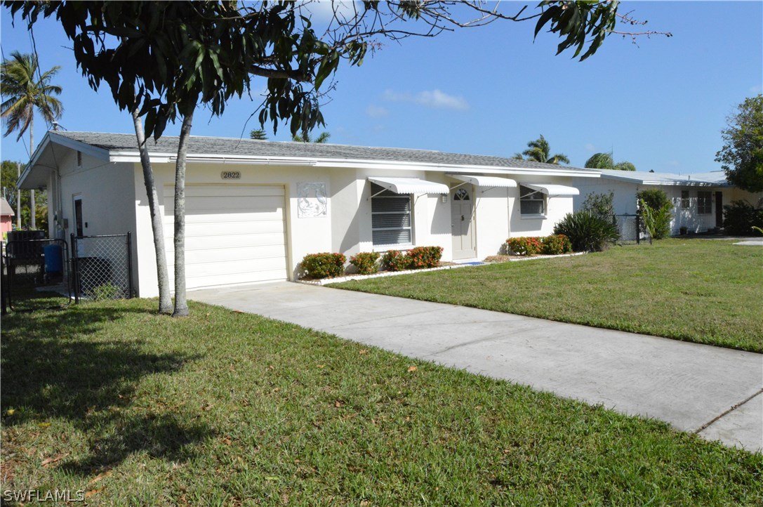 2822 Bruce Street Cape Coral, FL 33993 - Photo 1 of 20 a view of a white house with a big yard and potted plants
