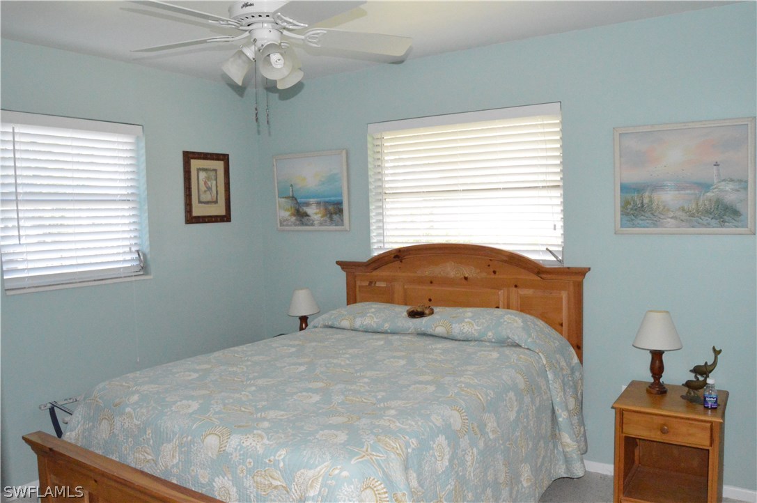 2822 Bruce Street Cape Coral, FL 33993 - Photo 12 of 20 a bedroom with a bed and a chandelier