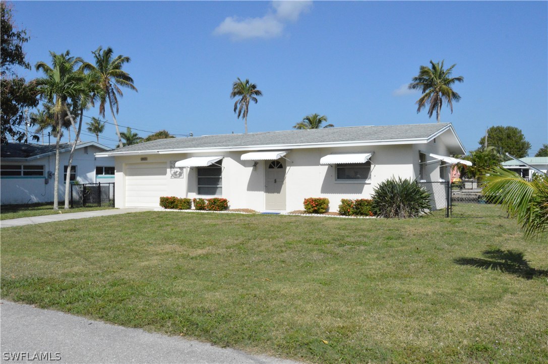 2822 Bruce Street Cape Coral, FL 33993 - Photo 2 of 20 a front view of house with yard and trees