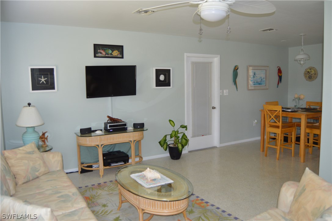 2822 Bruce Street Cape Coral, FL 33993 - Photo 10 of 20 a living room with furniture a fireplace and a flat screen tv