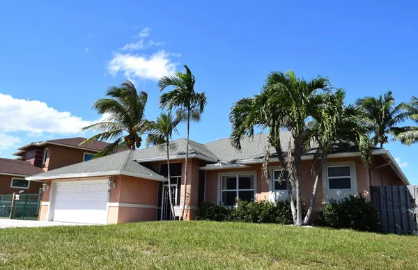 a view of a house with a yard and a garden