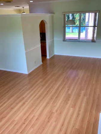 an empty room with a window and wooden floor