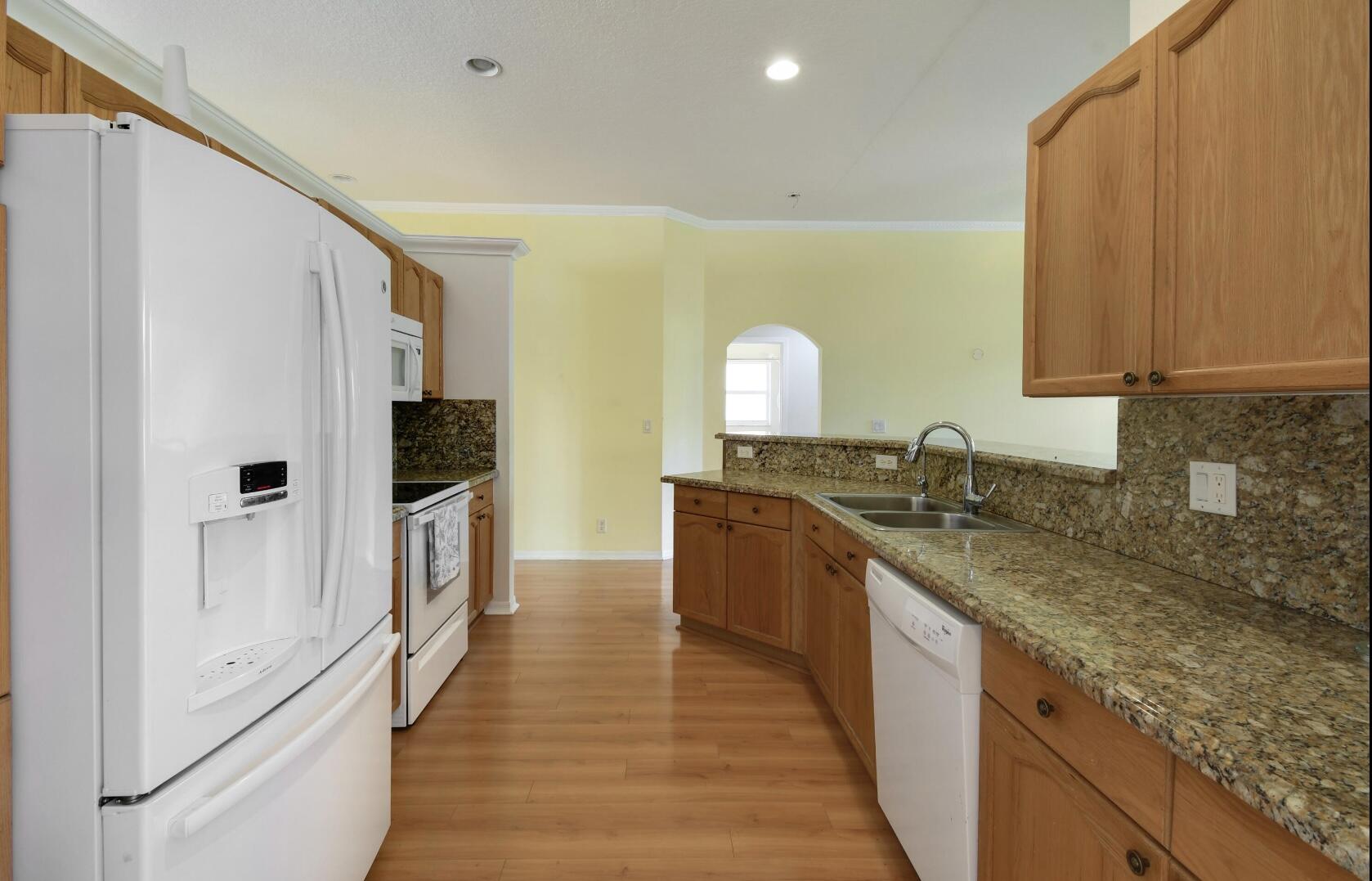 2215 Hypoluxo Road Lantana, FL 33462 - Photo 26 of 49 a kitchen with granite countertop a sink and a refrigerator