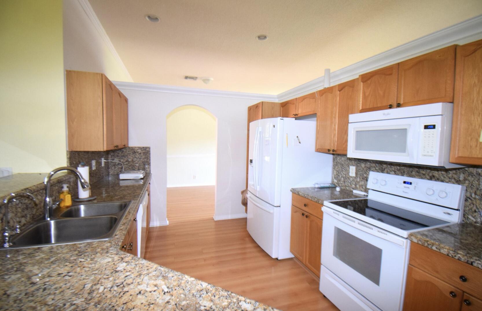 2215 Hypoluxo Road Lantana, FL 33462 - Photo 27 of 49 a kitchen with stainless steel appliances kitchen island granite countertop a stove a sink and a refrigerator