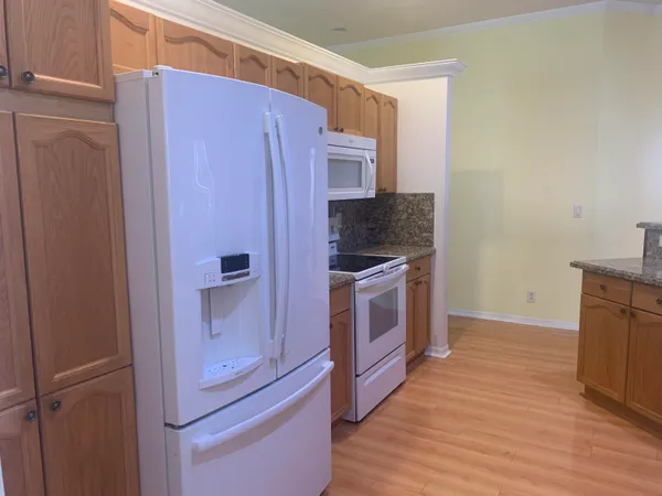 a kitchen with a sink refrigerator and microwave