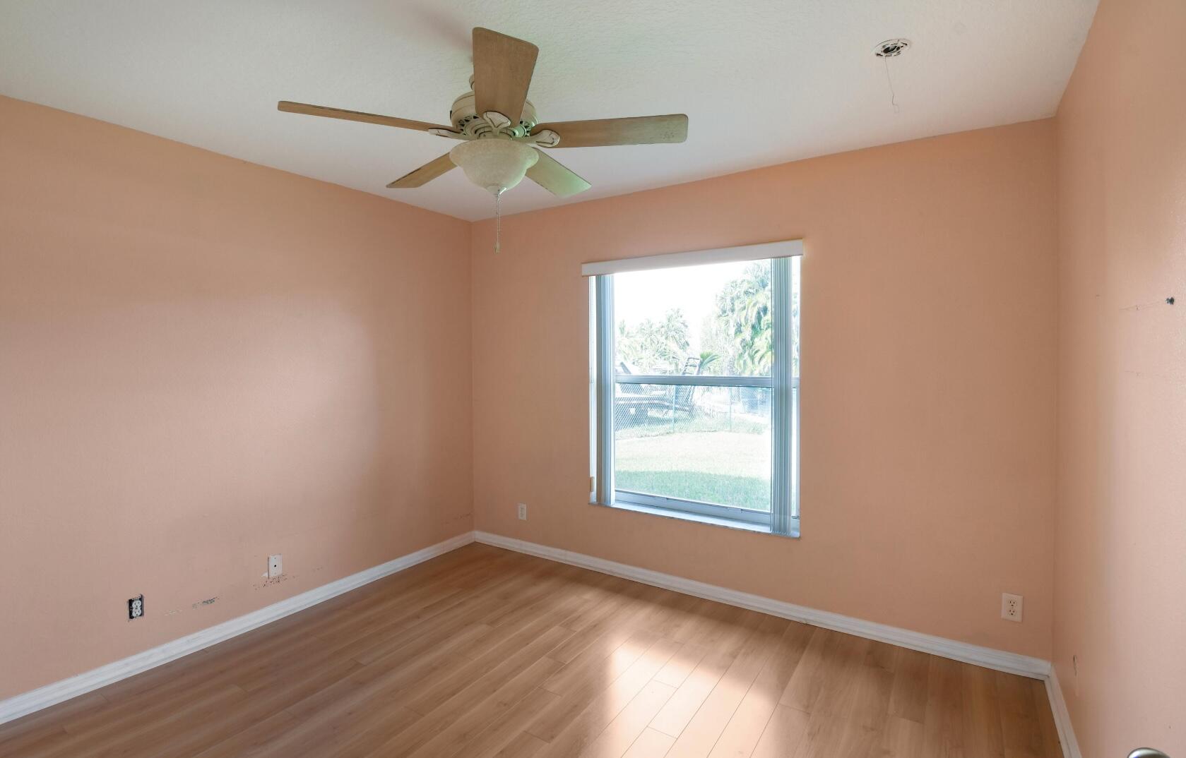 2215 Hypoluxo Road Lantana, FL 33462 - Photo 45 of 49 an empty room with wooden floor fan and windows