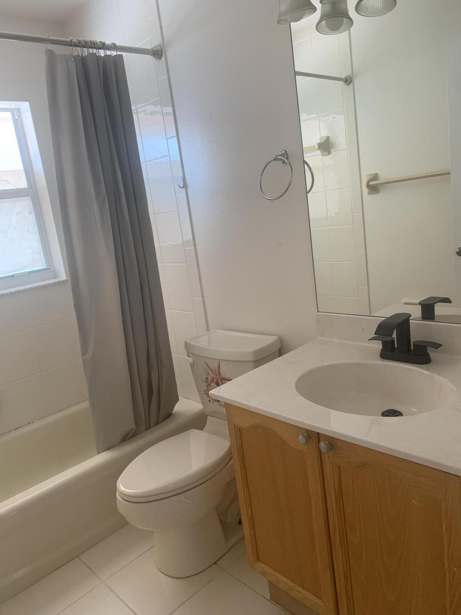 2215 Hypoluxo Road Lantana, FL 33462 - Photo 48 of 49 a bathroom with a sink a toilet a mirror and shower