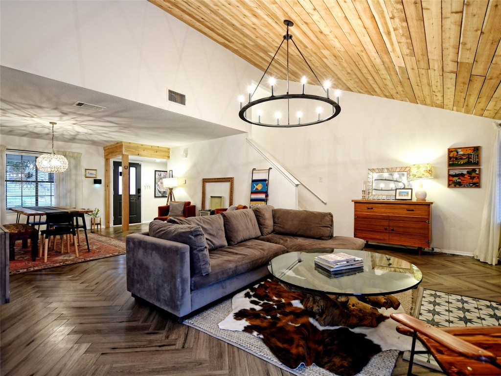 Living room with a chandelier, lofted ceiling, and wooden ceiling