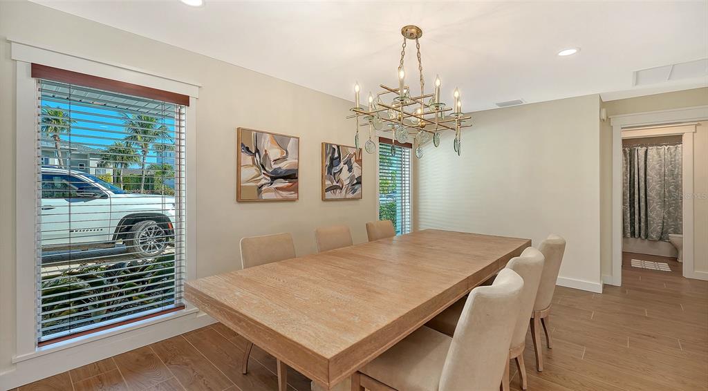 690 Old Compass Road Longboat Key, FL 34228 - Photo 11 of 69 a view of a dining room with furniture a chandelier and wooden floor