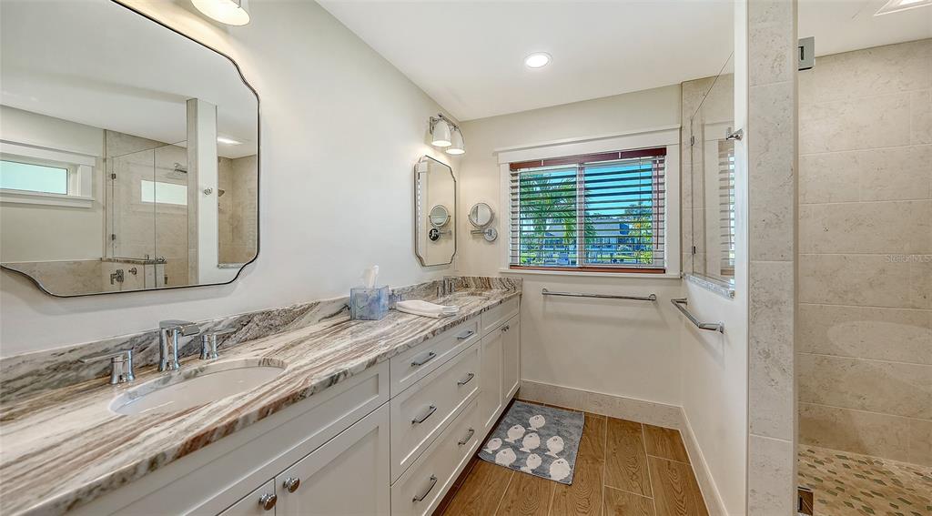 690 Old Compass Road Longboat Key, FL 34228 - Photo 34 of 69 a bathroom with a granite countertop sink a large mirror a vanity and a shower