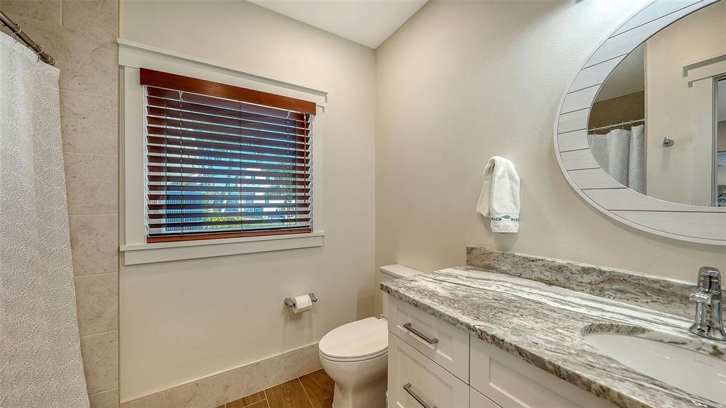 690 Old Compass Road Longboat Key, FL 34228 - Photo 46 of 69 a bathroom with a granite countertop toilet a sink and a mirror