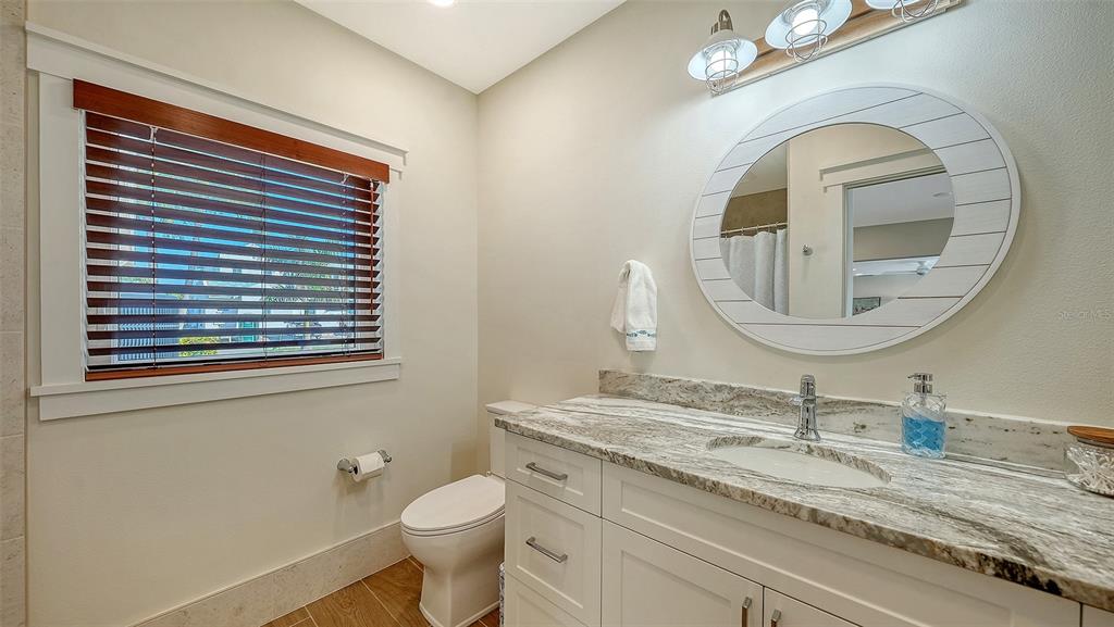 690 Old Compass Road Longboat Key, FL 34228 - Photo 47 of 69 a bathroom with a granite countertop toilet a sink and a mirror
