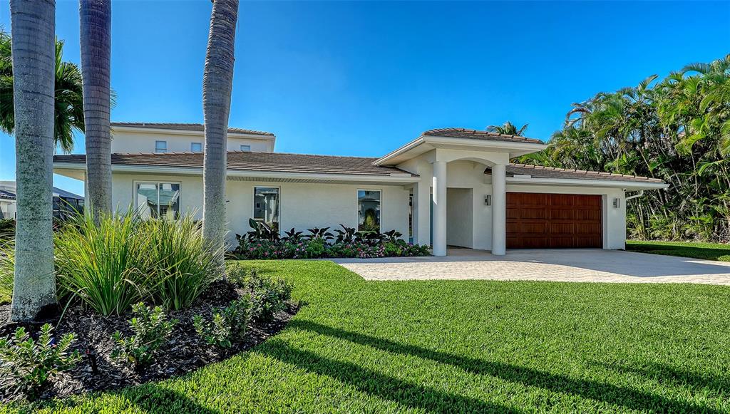 690 Old Compass Road Longboat Key, FL 34228 - Photo 6 of 69 a front view of a house with a garden and yard