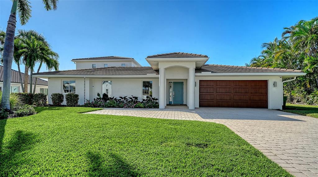 690 Old Compass Road Longboat Key, FL 34228 - Photo 7 of 69 a front view of a house with a yard and garage