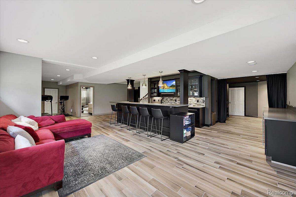 1422 Galena Rochester, MI 48306 - Photo 54 of 73 Expansive finished basement featuring wood-finish flooring, recessed lighting, and a built-in wet bar with pendant lighting