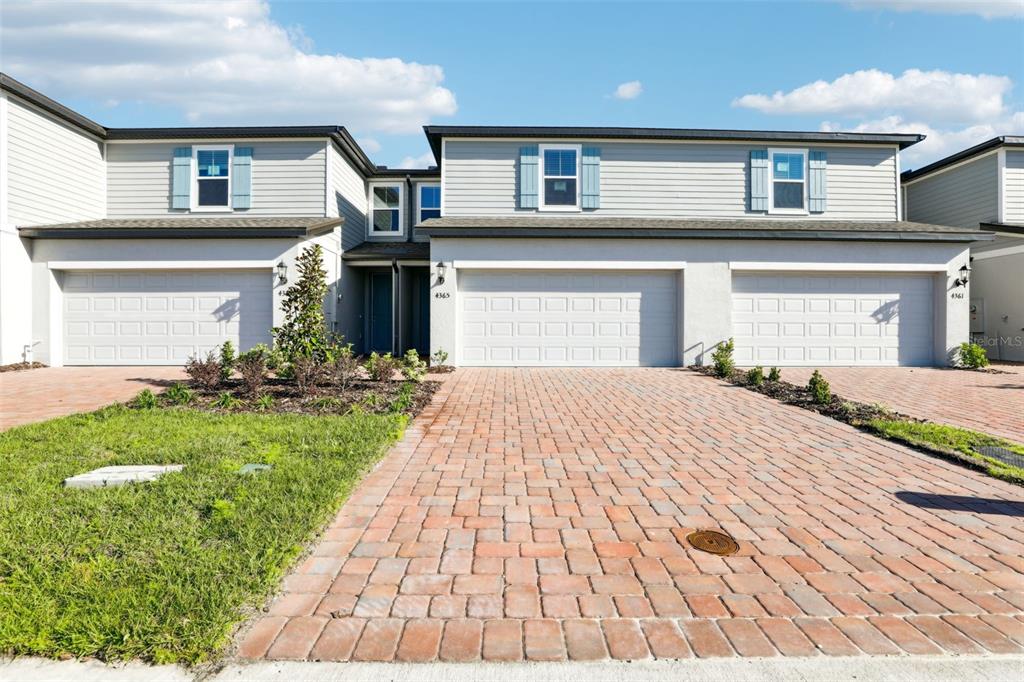 4365 Switchgrass Lane St. Cloud, FL 34772 - Photo 1 of 1 a front view of a house with a garden