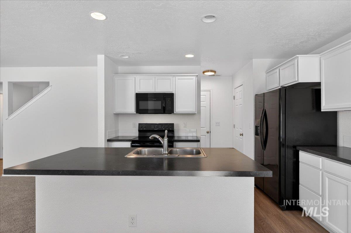 913 West Apple Pine Street Meridian, ID 83646 - Photo 11 of 32 Kitchen island with a stainless steel double sink and dark countertop