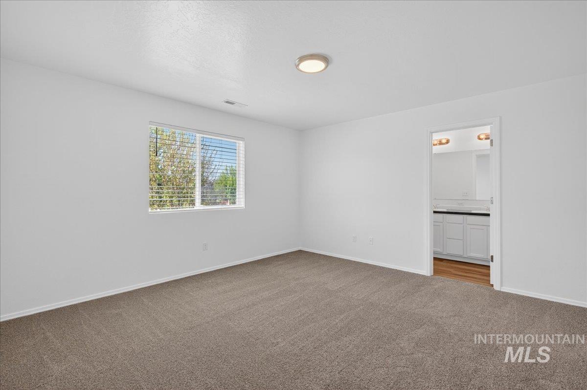 913 West Apple Pine Street Meridian, ID 83646 - Photo 13 of 32 Spacious room featuring neutral carpet flooring, white walls, and a window with blinds