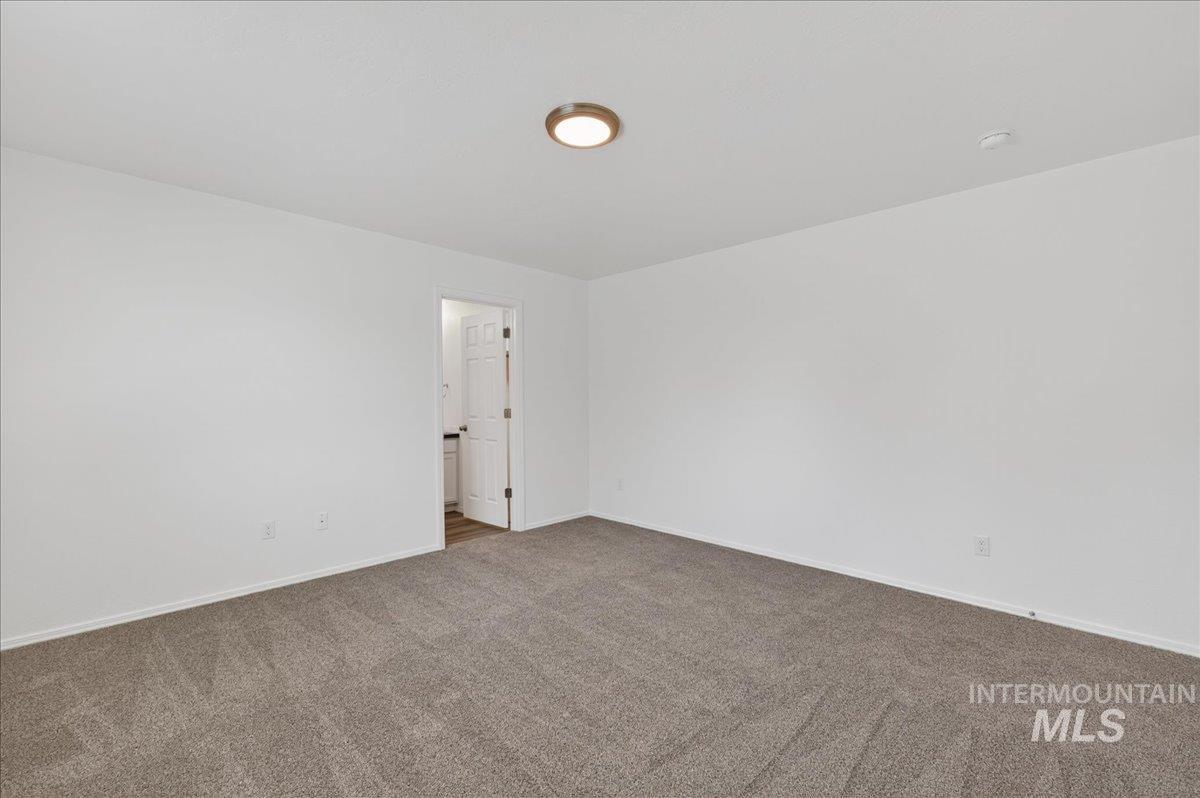 913 West Apple Pine Street Meridian, ID 83646 - Photo 15 of 32 Spacious room featuring neutral carpeting and white walls, complete with a ceiling-mounted light fixture and a standard interior door