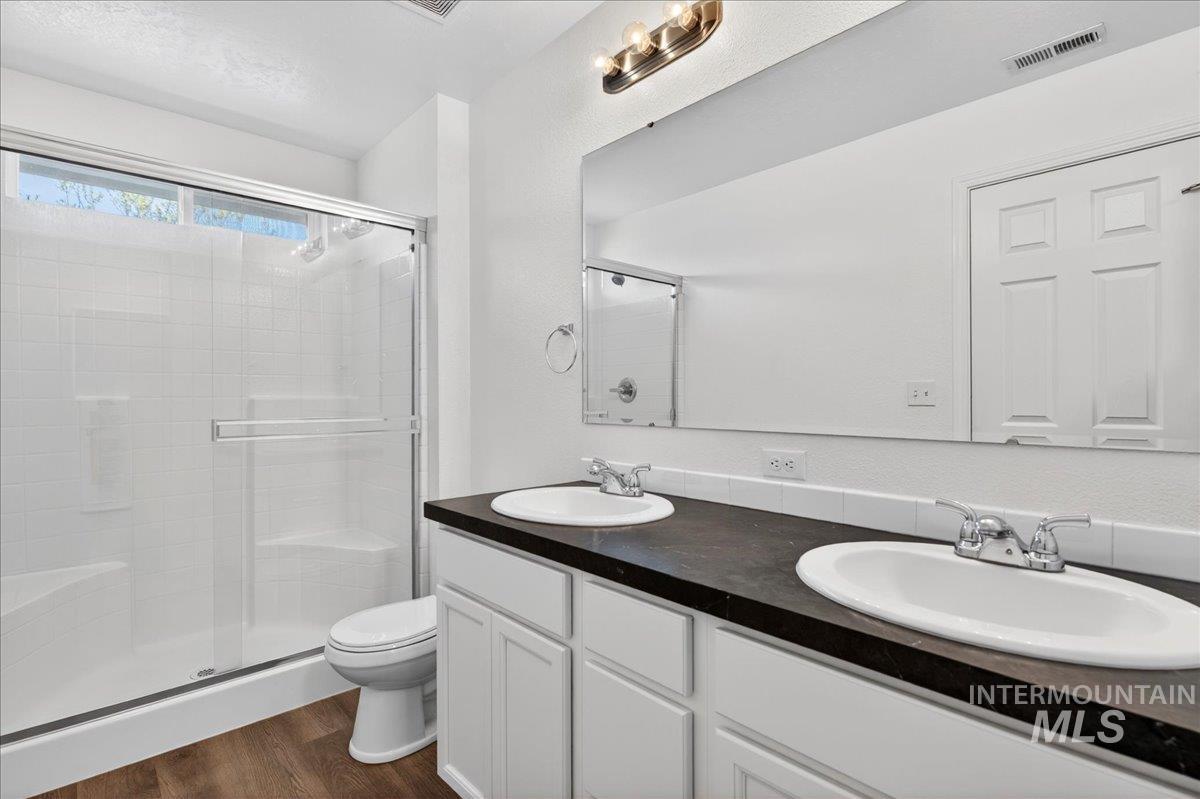 913 West Apple Pine Street Meridian, ID 83646 - Photo 20 of 32 Bathroom featuring a dual-sink vanity with white cabinetry, dark countertop, and integrated oval sinks