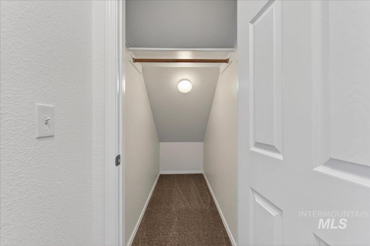913 West Apple Pine Street Meridian, ID 83646 - Photo 25 of 32 Carpeted closet with sloped ceiling, overhead lighting, and an integrated clothing rod