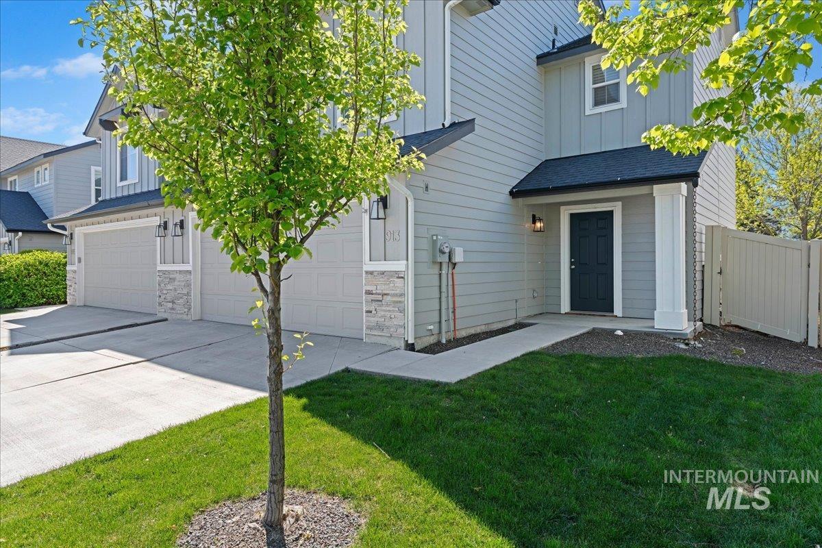 913 West Apple Pine Street Meridian, ID 83646 - Photo 3 of 32 Front exterior featuring light gray siding, a dark blue entry door, and stone facade accents