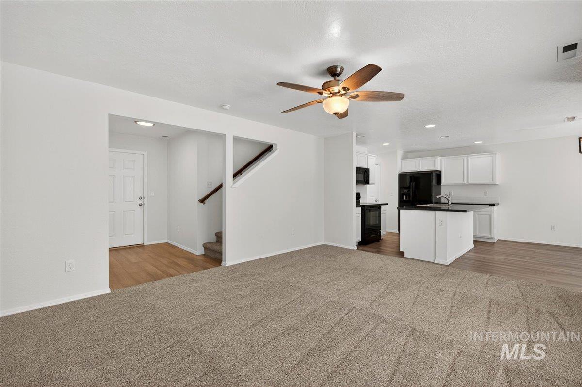 913 West Apple Pine Street Meridian, ID 83646 - Photo 5 of 32 Spacious main living area featuring neutral carpeting and a ceiling fan