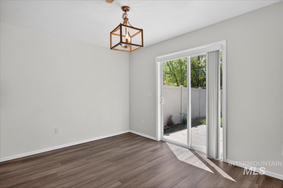 913 West Apple Pine Street Meridian, ID 83646 - Photo 8 of 32 Interior space featuring wood-finish flooring, light-toned walls, and a contemporary open-cage pendant light fixture