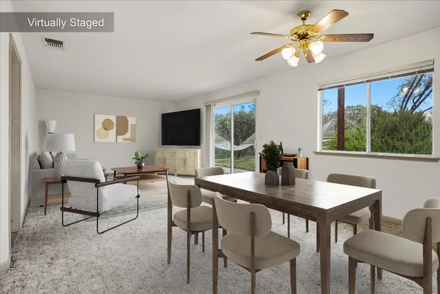 an empty room with windows and fan