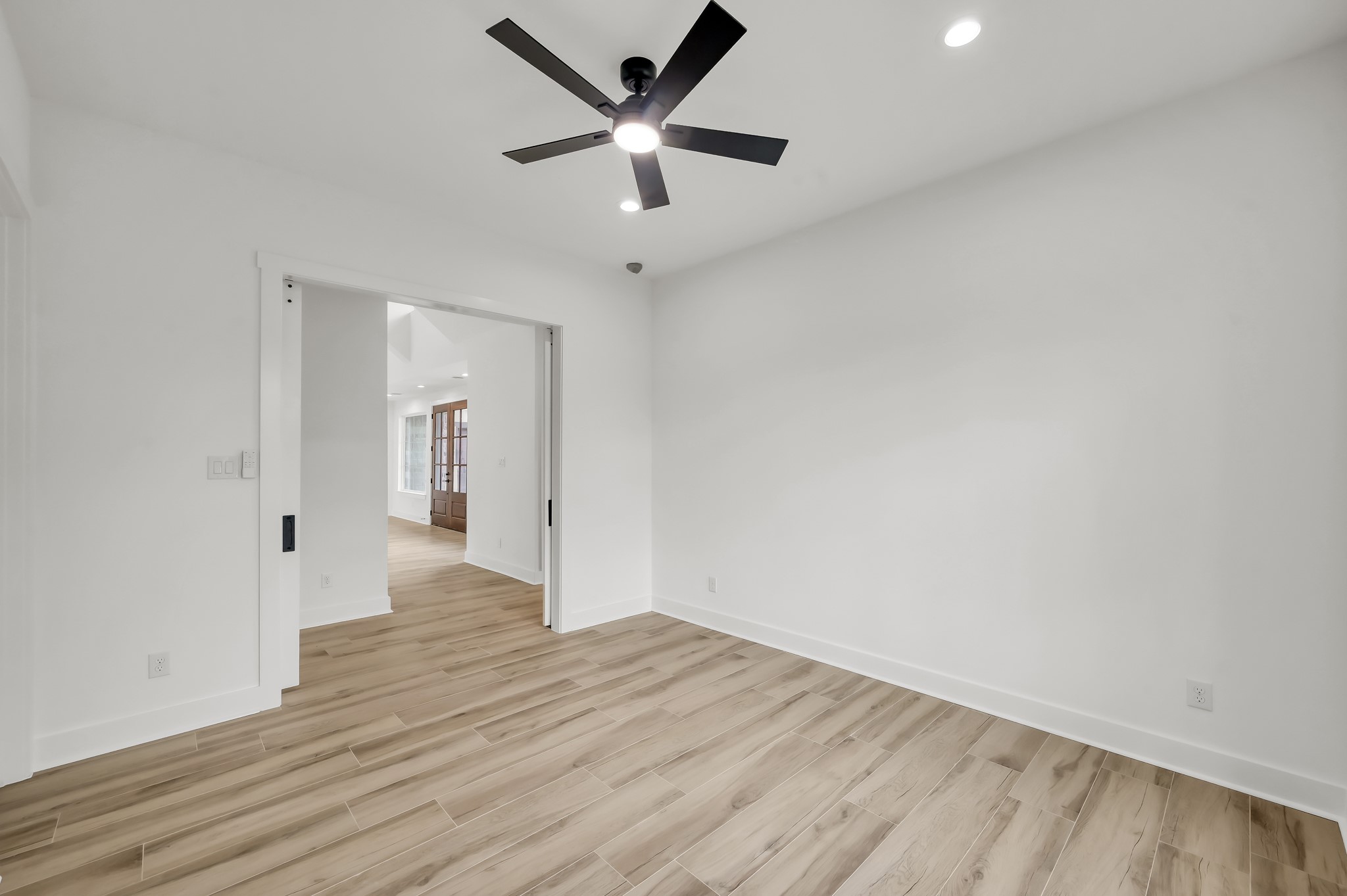 14742 Turquoise Trail Willis, TX 77378 - Photo 23 of 48 Spacious secondary bedroom featuring modern finishes, recessed lighting, and sliding barn doors that connect easily to the main living areas.