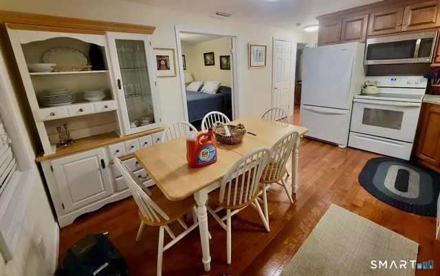 a kitchen with stainless steel appliances granite countertop a table chairs and a refrigerator