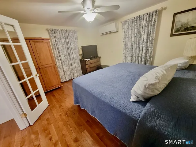 a bedroom with a bed and a flat tv screen on the dresser