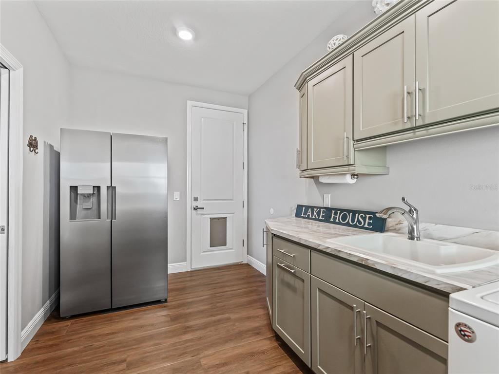 12943 Southeast Sunset Harbor Road Weirsdale, FL 32195 - Photo 45 of 87 a kitchen with stainless steel appliances granite countertop a refrigerator sink and cabinets