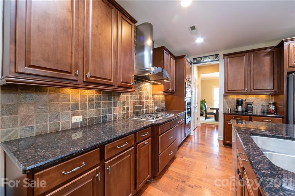 2721 Twinberry Lane Waxhaw, NC 28173 - Photo 2 of 29 a kitchen with stainless steel appliances granite countertop wooden cabinets a sink and dishwasher