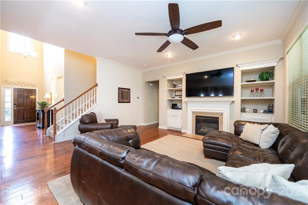 2721 Twinberry Lane Waxhaw, NC 28173 - Photo 10 of 29 a living room with furniture a fireplace and a flat screen tv