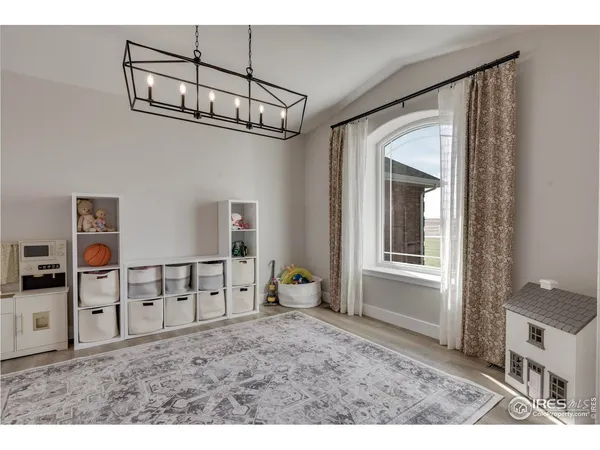 a view of a big room with a chandelier fan and windows