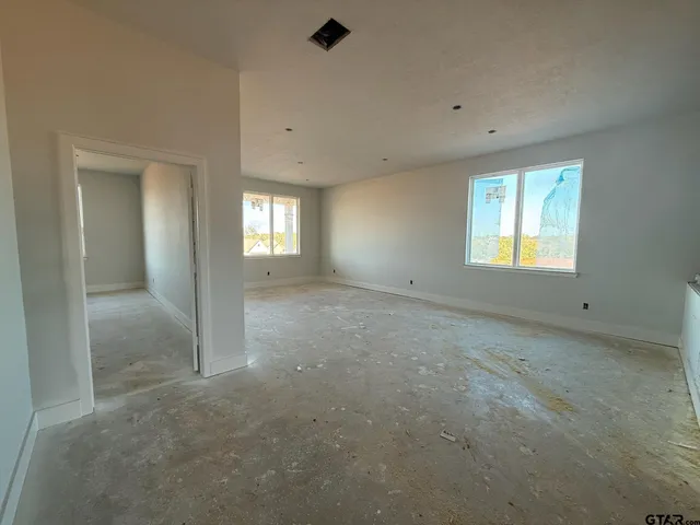 a view of an empty room with window and closet area