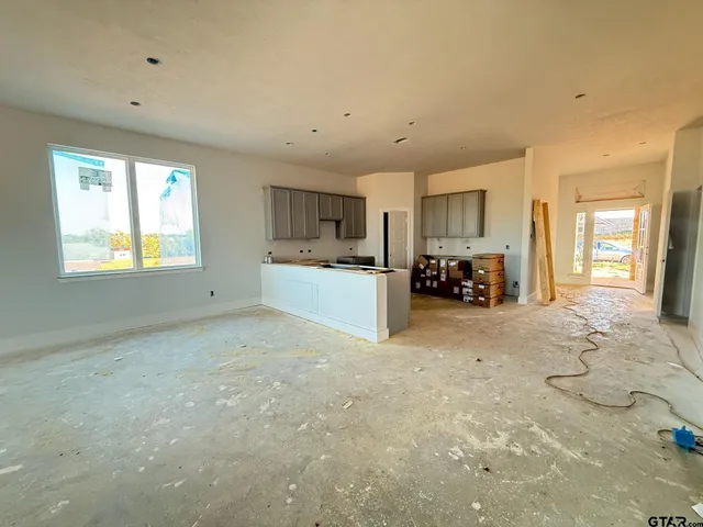a view of a livingroom with furniture cabinets and a kitchen