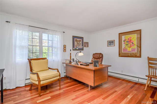 a living room with furniture a wooden floor and a window