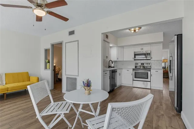 a workspace with wooden floor and a chandelier fan