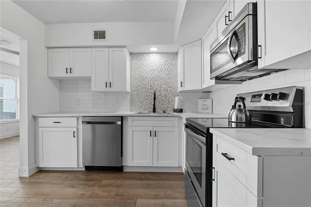 a kitchen with a refrigerator and a stove top oven