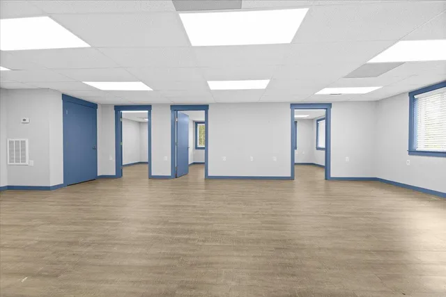 a view of an empty room with window and wooden floor